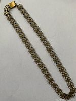 Full view of the antique heavy chain necklace showing entire length and hand-wrought chain links forming floral scroll pattern.