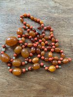 Full view of single-strand bead necklace with alternating bead colors and metal hook clasp