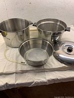 Full jelly-making pot set arranged on table showing all components including pot, perforated basket, base container, and lid