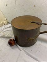 Photo showing large antique copper sauce pot with lid and apple for scale.