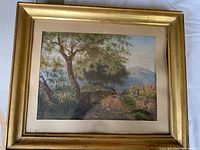 Framed landscape watercolour depicting trees, a dirt pathway with livestock and two figures, signed and dated.