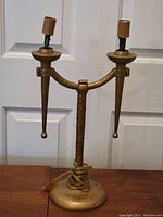 Full view of the double candle vintage Art Deco lamp showing the entire lamp from base to light sockets, highlighting the gold finish and overall structure.