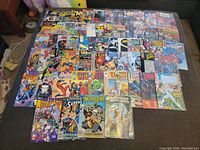 Overhead photo showing a wide layout of comic books mostly Marvel including X-Men, Wolverine, Daredevil, The Punisher, Fantastic Four and Spider-Man.