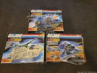 Three boxed GI Joe Battle Force 2000 vehicles arranged on floor