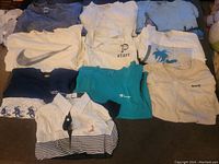 Image showing 11 shirts laid flat in rows, various colors and brands visible