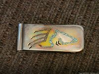 Top view of the sterling silver money clip showing turquoise chip inlay in a stylized design.