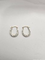 Pair of 10k gold hoop earrings shown with faceted diamond-cut pattern visible on one side.