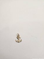 Photo of the small 10k gold anchor pendant on a white background showing its shape and condition