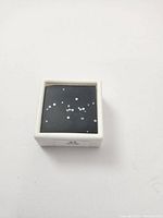 21 loose natural round mixed cut diamonds displayed on black surface in white box.