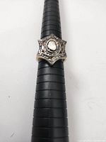 Top and angled view of star-shaped sterling silver ring featuring a central diamond stone with smaller surrounding stones.