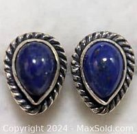 Close-up front view of the pair of sterling silver earrings with teardrop lapis lazuli stones and twisted rope design around stones.