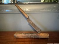 Full view of the antique cutting tool showing the steel blade mounted on a wooden base with a wooden handle.