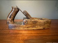 Side view of the antique Spear and Jackson wooden hand planer showing the handle and wooden body.