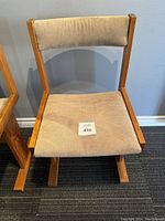 Front view of a mid century modern Danish teak side chair with beige upholstered seat and backrest, showing construction and condition.