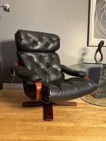 Front three-quarter view showing tufted seat, backrest and bentwood arm supports