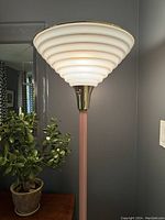 View of the lamp when lit showing warm light glowing through the stepped shade.