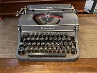 Front angle view of antique Underwood typewriter showing keyboard, ribbon and metal body.