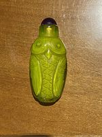 Front view of the bottle showing detailed owl carving in green agate.