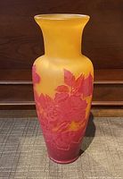 Full view of the yellow and red Galle glass vase with carved floral design