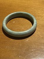 Full view of jade bangle bracelet showing circular form and color variations.