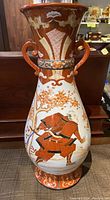 Full view of the antique Japanese Satsuma vase showing the body, neck, handles and detailed painted design under the glaze.