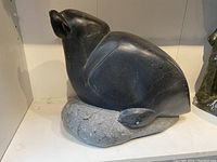 Front angled view showing overall sculpture form on natural stone base