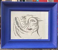 Frontal photo of the sketch drawing showing the stylized face with a tear and feather elements inside the blue velvet frame.