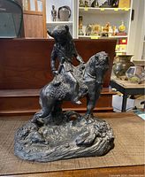 Front view of full sculpture showing figure on horse atop rocky base