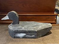 Front view of the wooden duck decoy showing the body and head shape with worn paint.