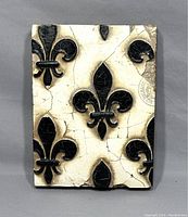 Front view of Sid Dickens Memory Block T-95 showing black Fleur de Lis on cracked white background.