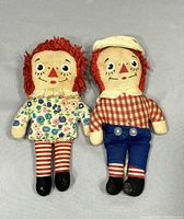 Both Raggedy Ann and Andy dolls together showing overall size, clothing, and condition.