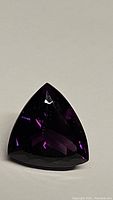 Deep purple amethyst gemstone, trillion cut, showing gemstone clarity and faceting details