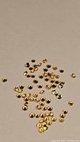 Multiple small yellow sapphire gemstones scattered on a neutral beige surface.