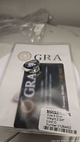 Ring placed on certification paperwork showing size 8.0mm, 2.0 ct weight, D color moissanite, certificate number 21264402