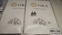 Pair of moissanite stud earrings displayed on top of the GRA moissanite report, showing clarity and color certifications, with price tag visible.