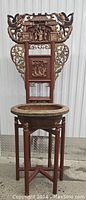 Front view of antique Chinese carved wash stand with ornate figural and floral carvings, basin placed in holder