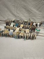 Wide view of multiple rows of glazed ceramic tile samples organized on metal rods, showing variety in size and colors.