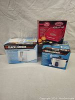 Photo of all three appliance boxes: Black & Decker toaster, Black & Decker rice cooker, and Betty Crocker Burger Bites Slider Grill.
