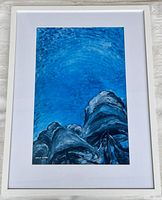 Full view of framed Emily Carr print showing the blue sky and tree tops composition, white mat and frame.