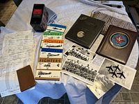 Photo showing the collection of books, log book, photographs, documents and memorabilia arranged on a table.