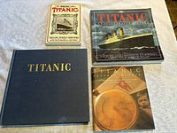 Four Titanic books laid flat on a patterned surface showing front covers, including one titled 'The Sinking of the Titanic' and another with a night view of the ship.