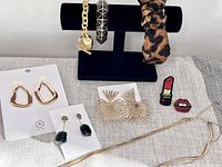 Full lot showing jewelry and accessories displayed on fabric and black holder stand