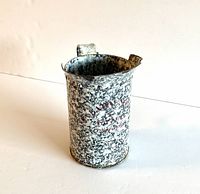 Front and side view of vintage graniteware 1 pint measure showing speckled black and white enamel and stencilled red lettering.