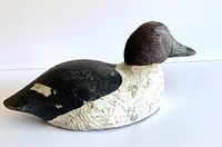 Side and three-quarter views of the vintage wooden duck decoy showing painted details, wear, and overall shape.