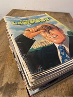 Stack of 23 vintage National Lampoon magazines showing side bindings and visible spine wear.
