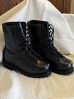 Front and side view showing polished black leather, laces, and boot shape