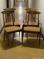 Set of four Mid Century Modern dining chairs, two with arms and two without, showing overall condition and design.