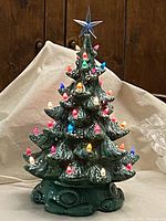 Full view of vintage ceramic Christmas tree decorated with multi-color lights and a blue star topper.