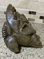 Side view showing bear head and turtle head motifs