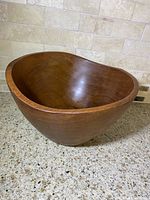 Full view of the vintage Mid-Century Modern wooden salad bowl showing its asymmetrical unique form and smooth polished finish.